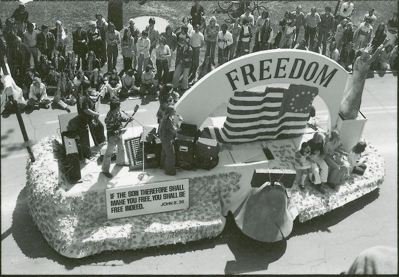 A 1976 bicentennial float "Freedom" in the VEISHEA parade. Replicas of the Liberty Bell, Statue of Liberty, and 1776 American flag are displayed. A band performs on the flatbed.