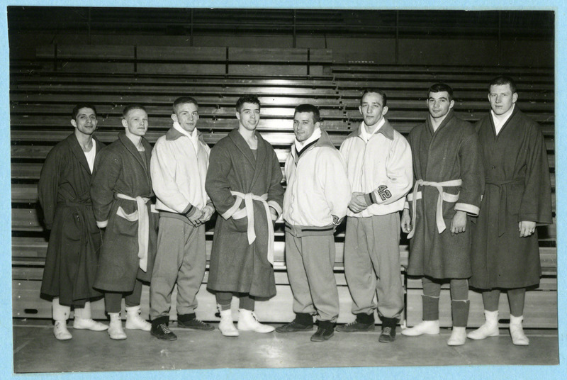 The Iowa State University Big Eight Conference Wrestling Champions are standing in front of the bleachers, 1958.