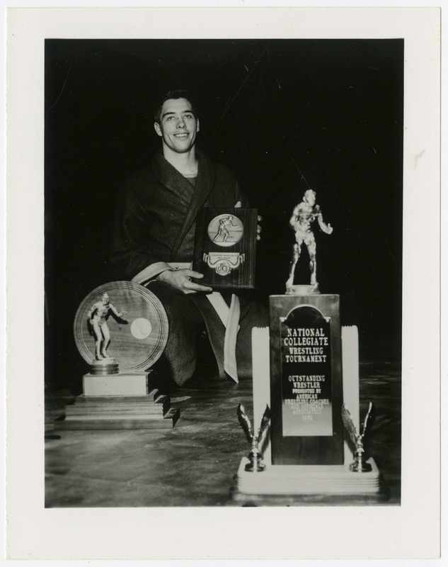 Ron Gray, Iowa State University wrestler, is holding an award, 1960.