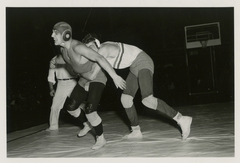 Captain Bob Wilson (right) Grapples with a wrestling opponent.