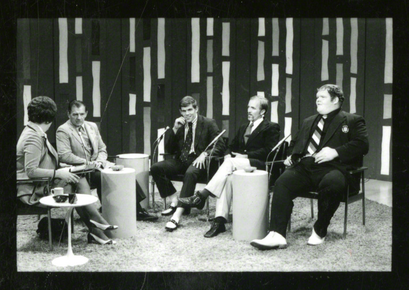 Coach Harold Nichols (second from the left) speaks at WOI-TV. Ben Peterson, Chris Taylor (far right), and an unidentified man sit next to him.