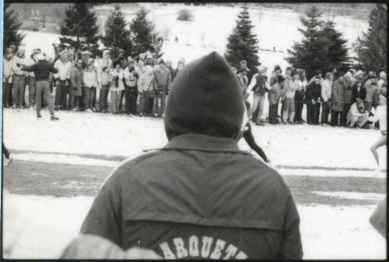 Several runners at the NCAA Women's cross-country meet Milwaukee, Wisconsin, on November 25, 1985, several hours before the plane crash. Spectator obstructs view.