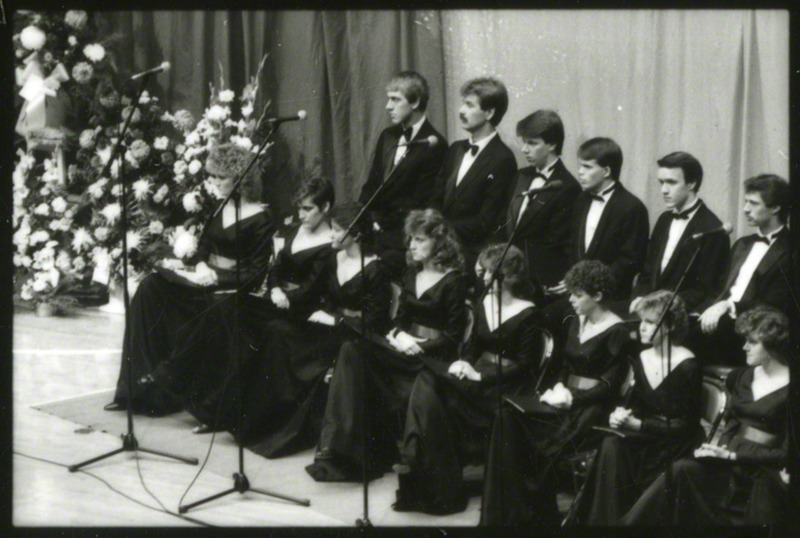 The ISU Chamber Singers are sitting on the stage at the memorial service.