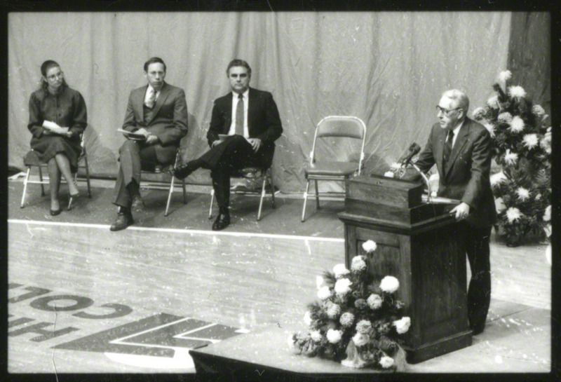 University president Dr. W. Robert Parks is speaking from the podium at the memorial service.