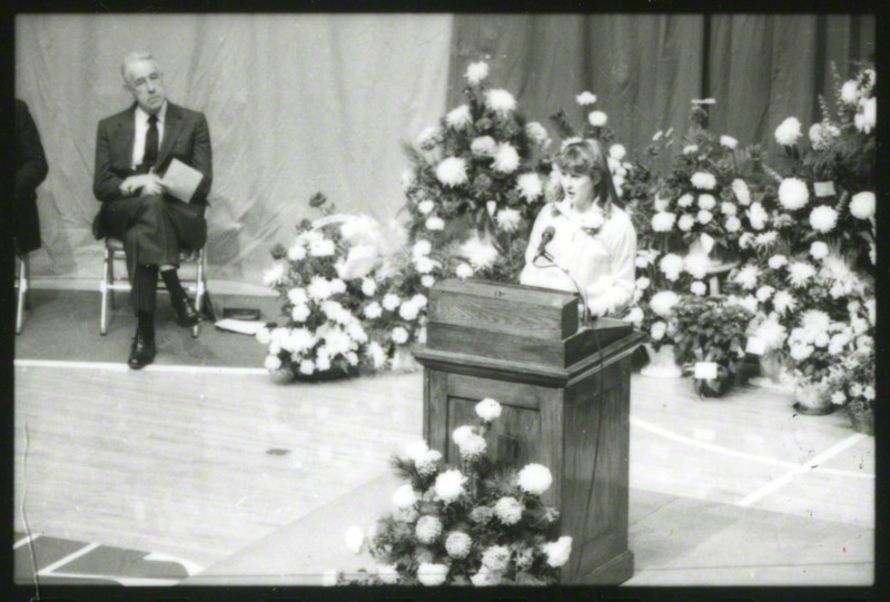 An unidentified women is speaking from the podium at the memorial service.