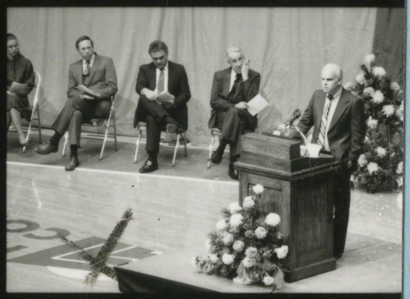 Tom Lichtenberg is at the podium giving a eulogy for cross-country runner, Julie Rose.