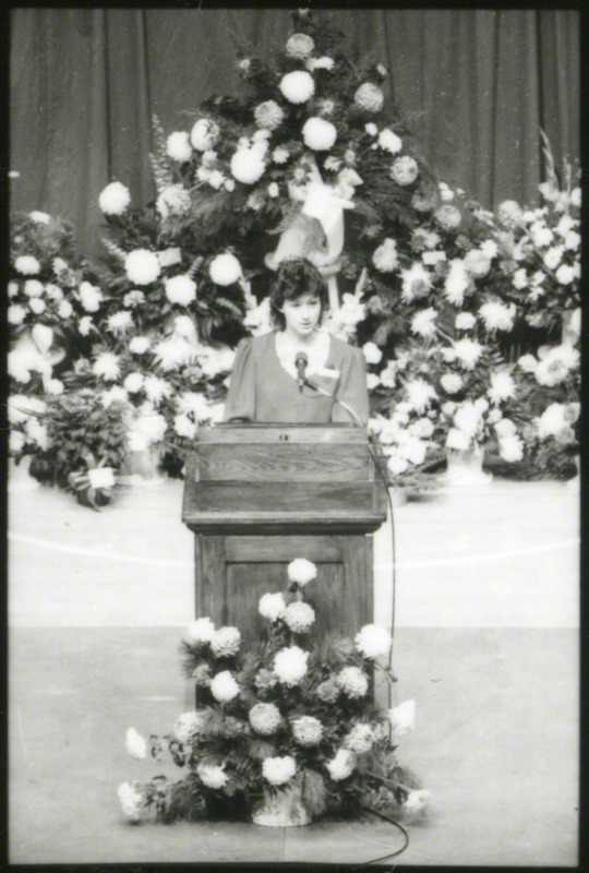 An unidentified woman is speaking at the podium.