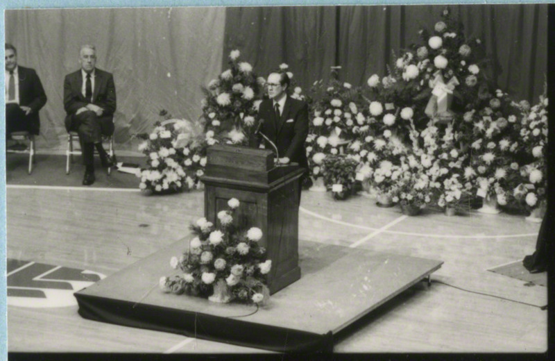 An unidentified man is speaking from the podium at the memorial service, 1985.