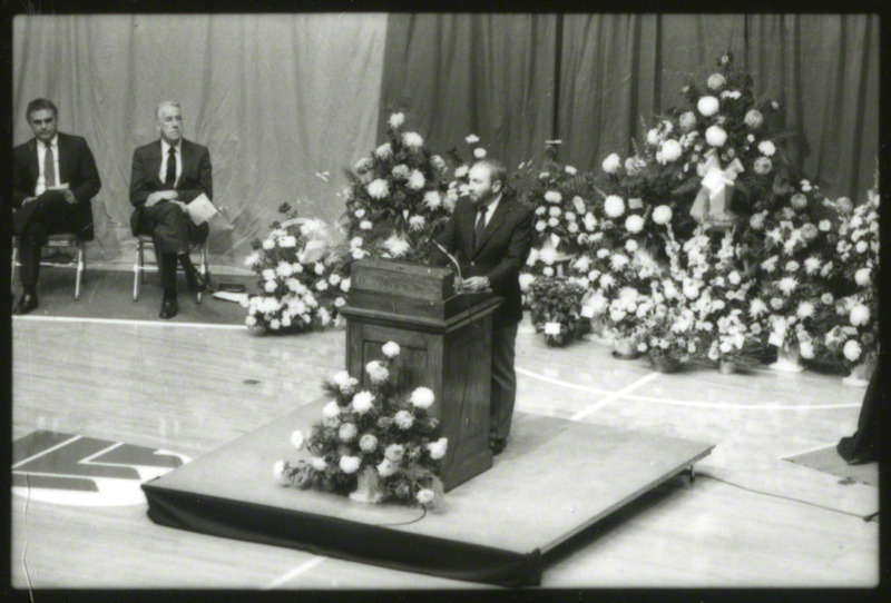 An unidentified man is speaking from the podium at the memorial service, 1985.