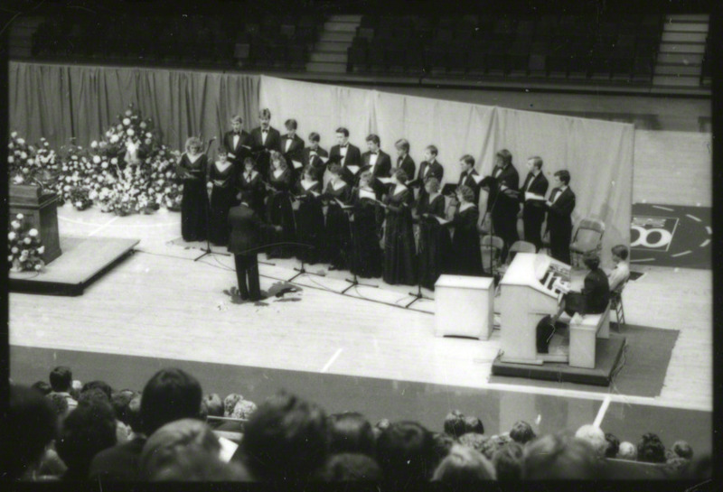 Josef Knott is conducting the Iowa State University Chamber Singers at the memorial service. Organist Lynn Zeigler-Dickson is accompanying the singers, 1985.