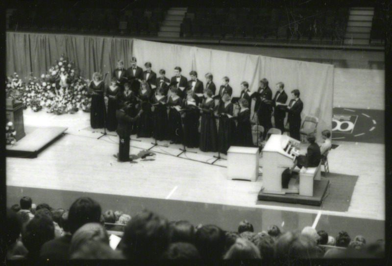 Josef Knott is conducting the Iowa State University Chamber Singers at the memorial service. Organist Lynn Zeigler-Dickson is accompanying the singers, 1985.