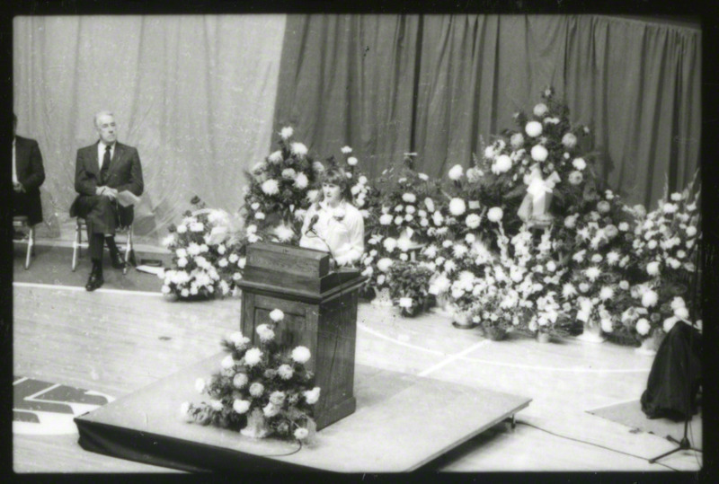 An unidentified women is speaking from the podium at the memorial service, 1985.