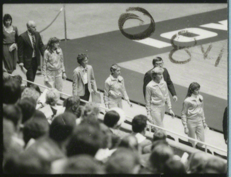 The speakers and women's cross-country team members are entering Hilton Coliseum for the memorial service, 1985.