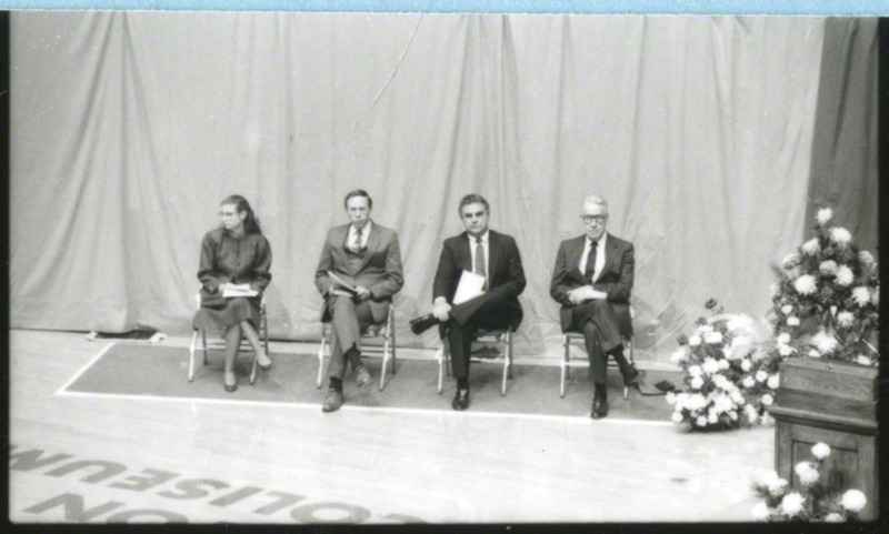 Some of the speakers for the memorial service are seated to the left of the podium. From left to right they are Reverend Ann Clay Adams, Reverend Dean Johnson, Max Urich, and Dr. W. Robert Parks, 1985.