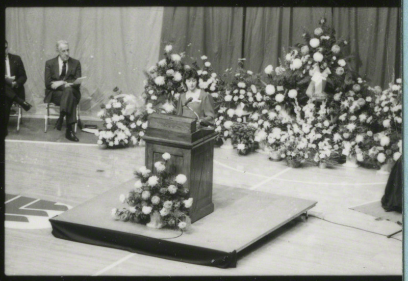 An unidentified woman is speaking at the podium, 1985.