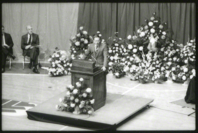 The Reverend Dean Johnson is speaking at the podium, 1985.