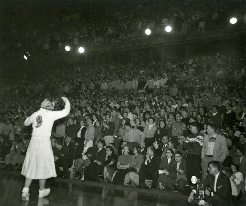 An Iowa State cheerleader stands in front of the crowd.