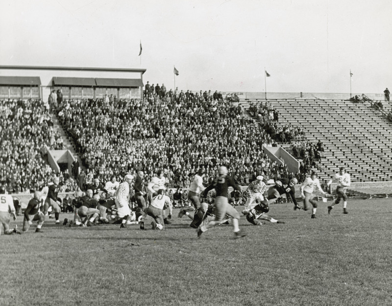 A football game being played before a large group of spectators.