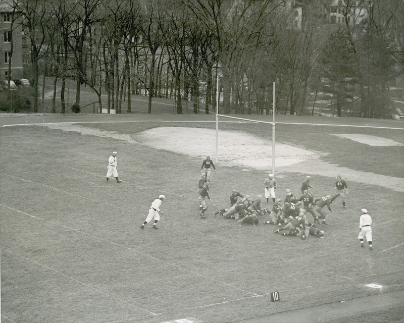 A football game is in progress. Lincoln Way is shown behind the trees.