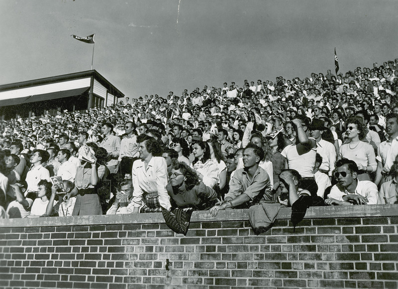 Spectators at a football game, taken from the sidelines.