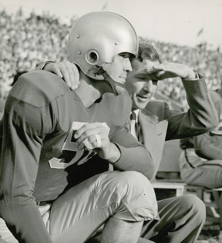 Taken during the 1951 homecoming football game against Kansas State. Coach Emmet R. "Abe" Stuber squatting with one of his football players.