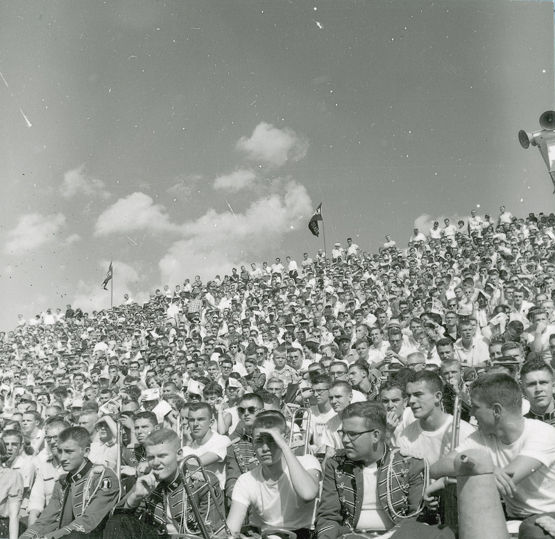 A crowd of spectators in a watching a homecoming football game. This image is part of a set of images that includes: 24-6-G.Football.1871-5-7-2; 24-6-G.Football.1871-5-7-3 ; and 24-6-G.Football.1871-5-7-4.