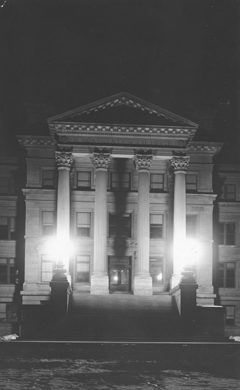 Narrowly focused on the portico, this image depicts the front of Beardshear Hall at night with only the step lights turned on. The steps are shrouded in shadow.