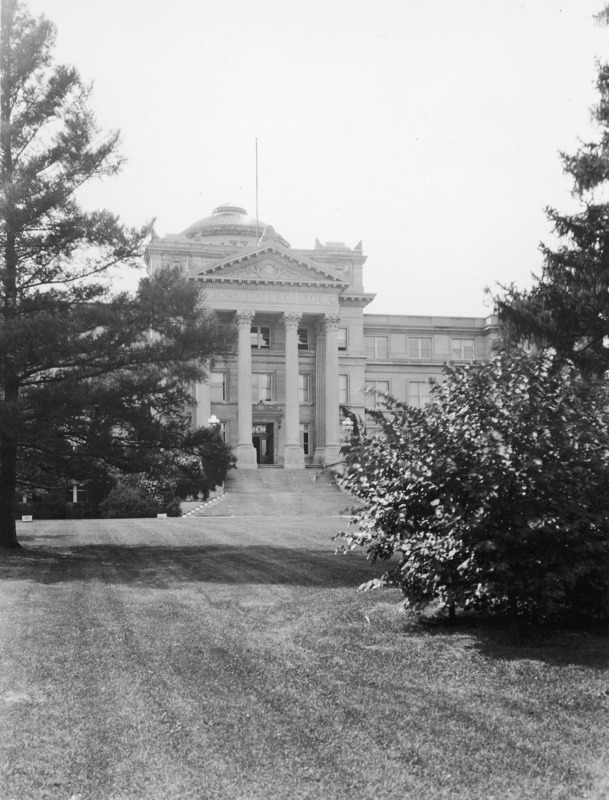 The central front of Beardshear Hall, framed by obscuring trees on either side.