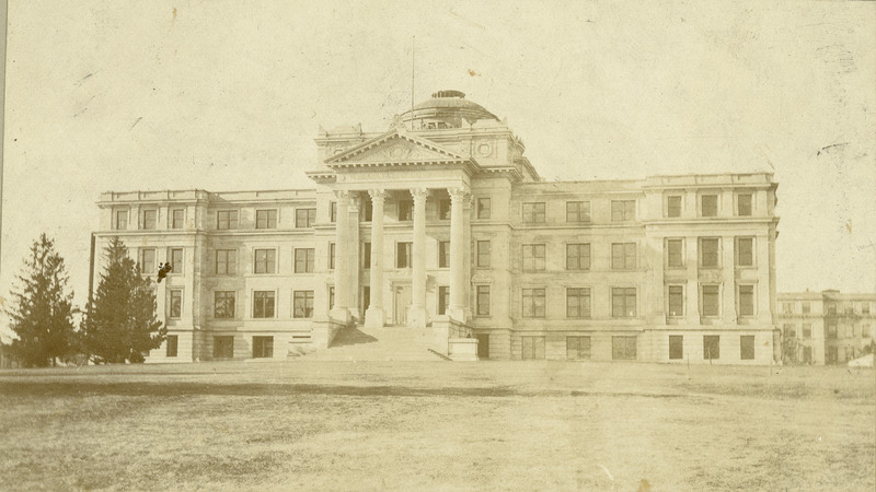 The front of Beardshear Hall shortly after completion. No landscaping for the building has yet been installed. A field of short grass is shown in front of the building. No street or sidewalk can be seen.