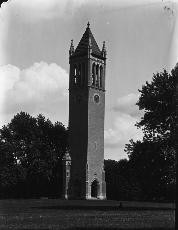 The Campanile in the summer of 1906. The photograph is close up, showing only the tower, a piece of lawn, and background trees. Everything is in deep shadow.