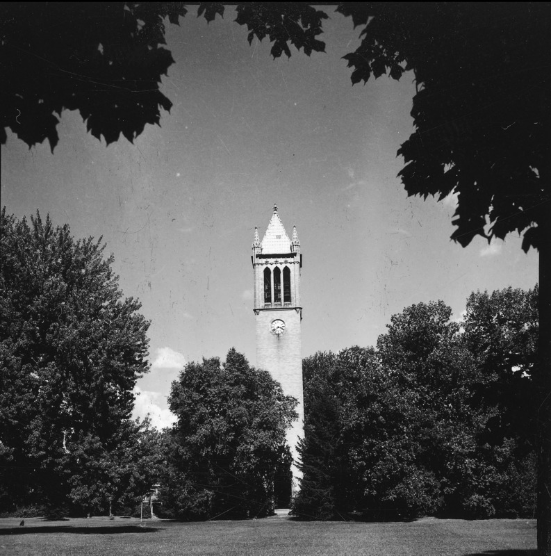 The Campanile as seen through an opening in the surrounding grove of trees. Clock shows 3:40. Fully leafed tree branches and foreground shadows frame the view of the Campanile. One of a set of four very similar photographs, the others of which are: 4-8-I.Campanile.230-7-5-1; 4-8-I.Campanile.230-7-5-3; and 4-8-I.Campanile.230-7-5-4.