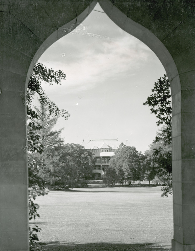 The front of Catt Hall framed in the arch of the Campanile. Catt Hall is in the background and the Campanile arch is in the foreground.