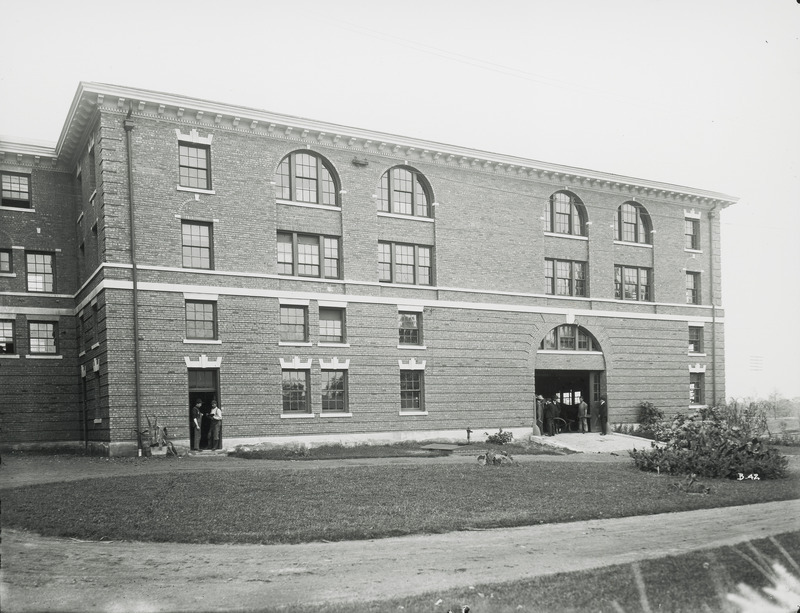 The side of Catt Hall with an open sliding door. Several individuals are standing in front of the door.