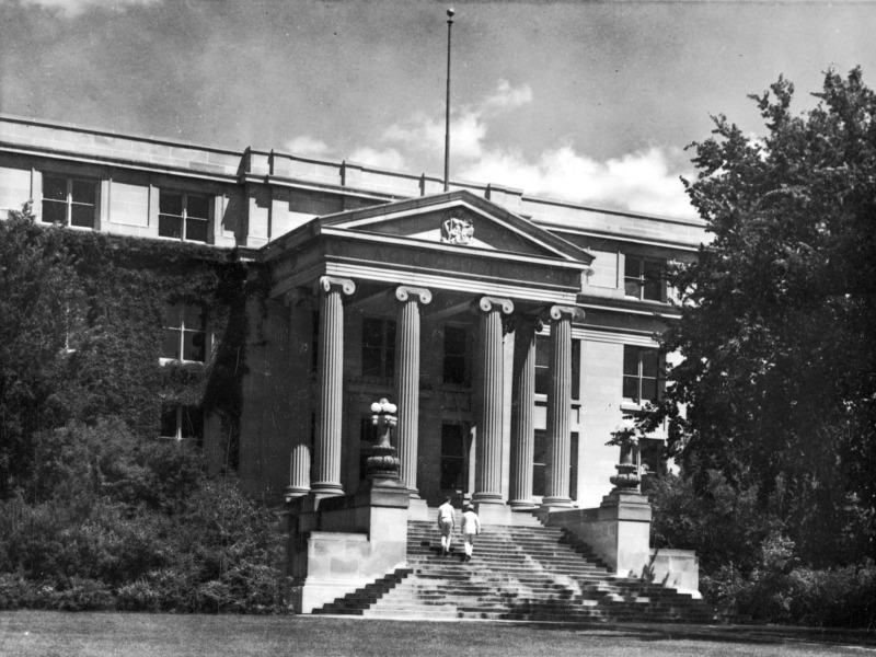 Two men in light-colored clothing climb the steps of Curtiss Hall.