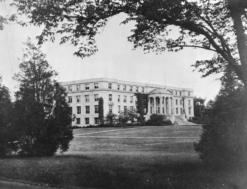 Agriculture Hall (Curtiss Hall) is viewed from the northwest through trees, showing the north and west elevations with ivy starting to grow on the walls.