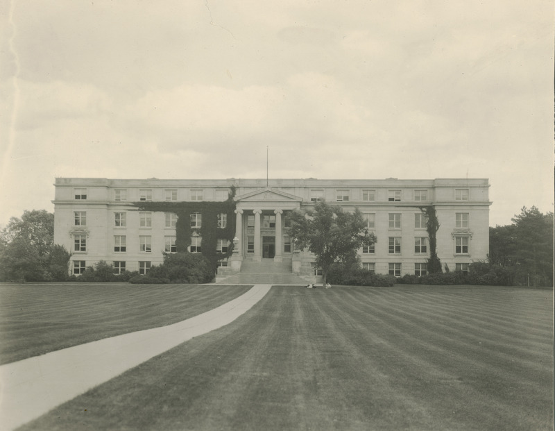 The Agriculture Hall (Curtiss Hall) front (west) facade is viewed from central campus, while students lounge under the tree in front of the building.