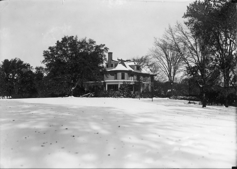 This winter view of the Knoll shows the southeast corner of the building, and the surrounding trees and bushes. There is snow on the building roof and the ground.