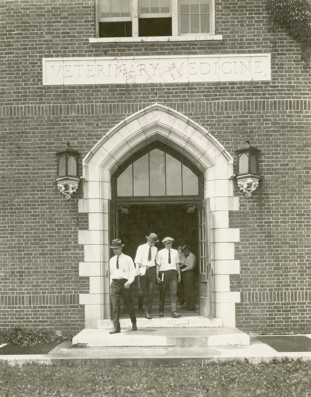 Several men walking out the entrance of Lagomarcino Hall (then called the Quadrangle) in 1923.