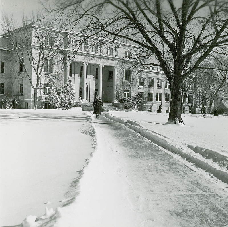 MacKay Hall in 1953. Surrounding area is covered in snow. Woman is seen walking away from the building.