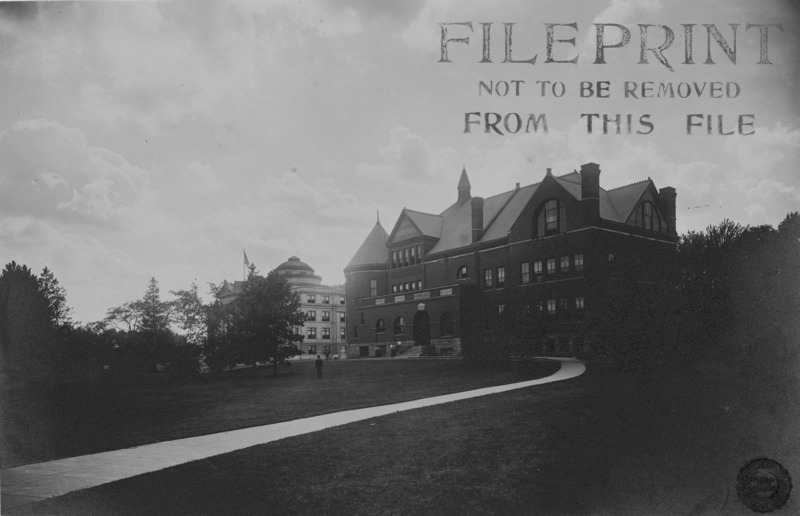 A man is standing on the lawn in front of Morrill Hall. Portions of Central Building (Beardshear Hall) can be seen in the distance.