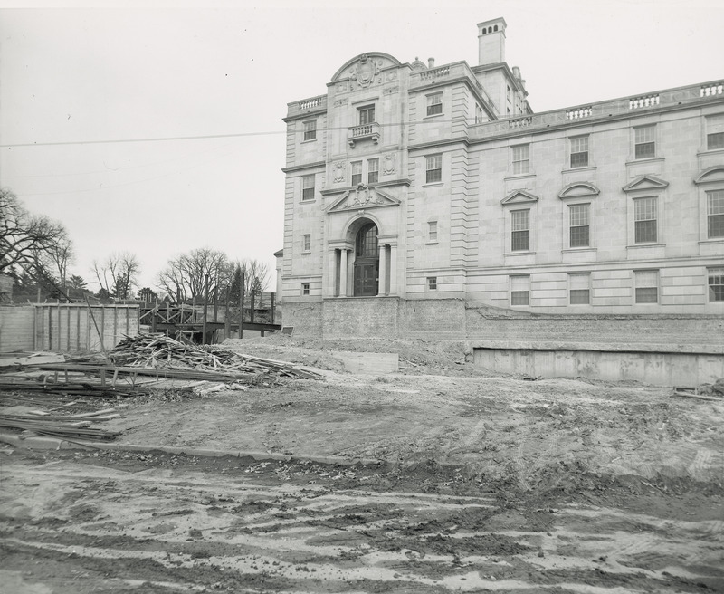 This 1950 photograph shows the west side of the Memorial Union with excavation for what will become the west terrace. The foundation walls are exposed and steel framework for the northwest addition is seen. A crane and construction framing are on the left side.