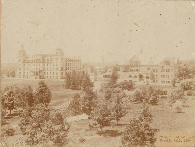 An aerial view of Old Main and Morrill Hall from central campus. The Hub and other campus buildings can be seen between and behind the two main college buildings.