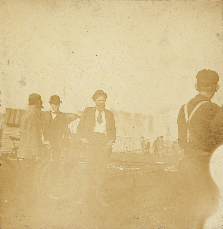 Men milling about with William Beardshear facing the camera.