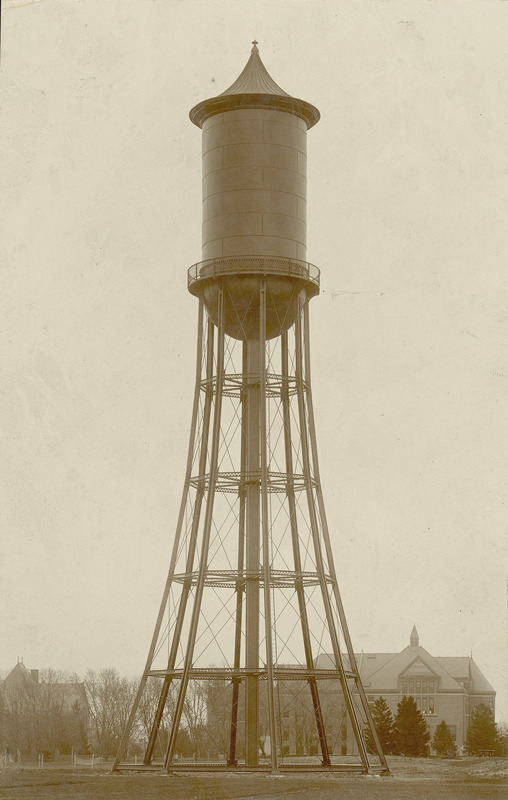 A full-length view of the Marston Water Tower occupies the center frame with Morrill Hall and The Hub in the distant background.