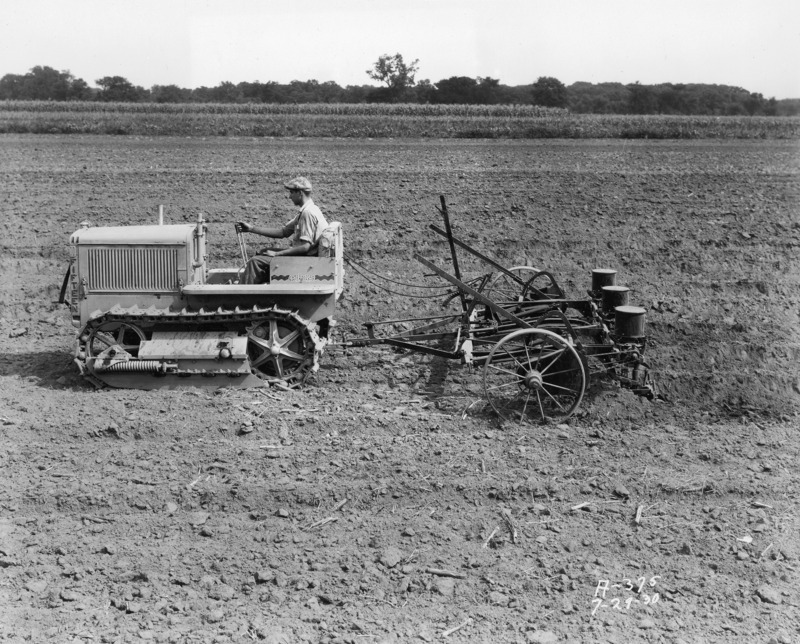 Image of a Caterpillar Fifteen in second speed listing and planting three rows of corn with a Rock Island Three-Row Lister, Milan, Ill. The photograph was taken in July 1930.