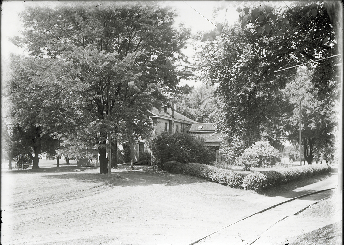 Photograph of the north-west corner of the Farm House with Dinkey tracks in the foreground. Annotation: “Horse barn redesigned in 1930 for Landscape Architecture.”