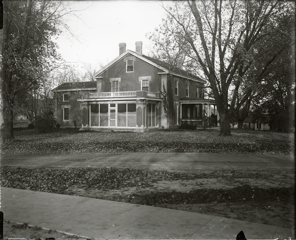 Photograph showing the south-west corner of the Farm House including both the west and south porches. The Creamery, First can be seen in the background to the right (west) of the Farm House. Annotation: “Farm House ca. 1911.”