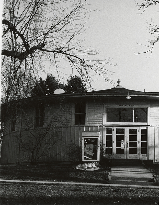 Photograph of the Shattuck Theatre showing the exterior south doors and a signboard containing a poster for "Fiddler on the Roof."
