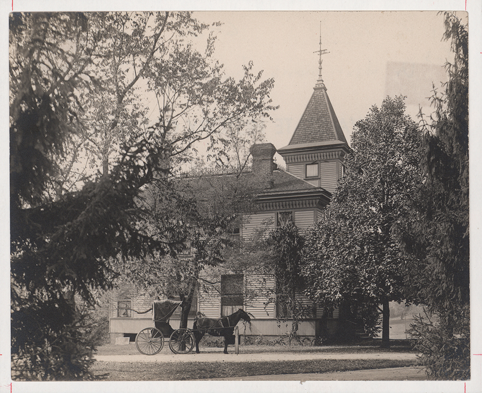 Photograph of the Sanitary Building from the side. A horse and buggy stand in in the foreground. The photograph is from sometime between 1904-1909.