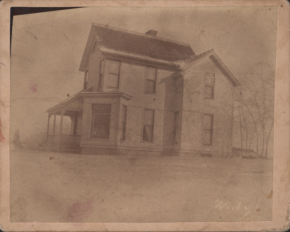 Photograph of Coburn House from the side. Snow is on the gruond and visible on the edge of the roof. The house is two stories high.